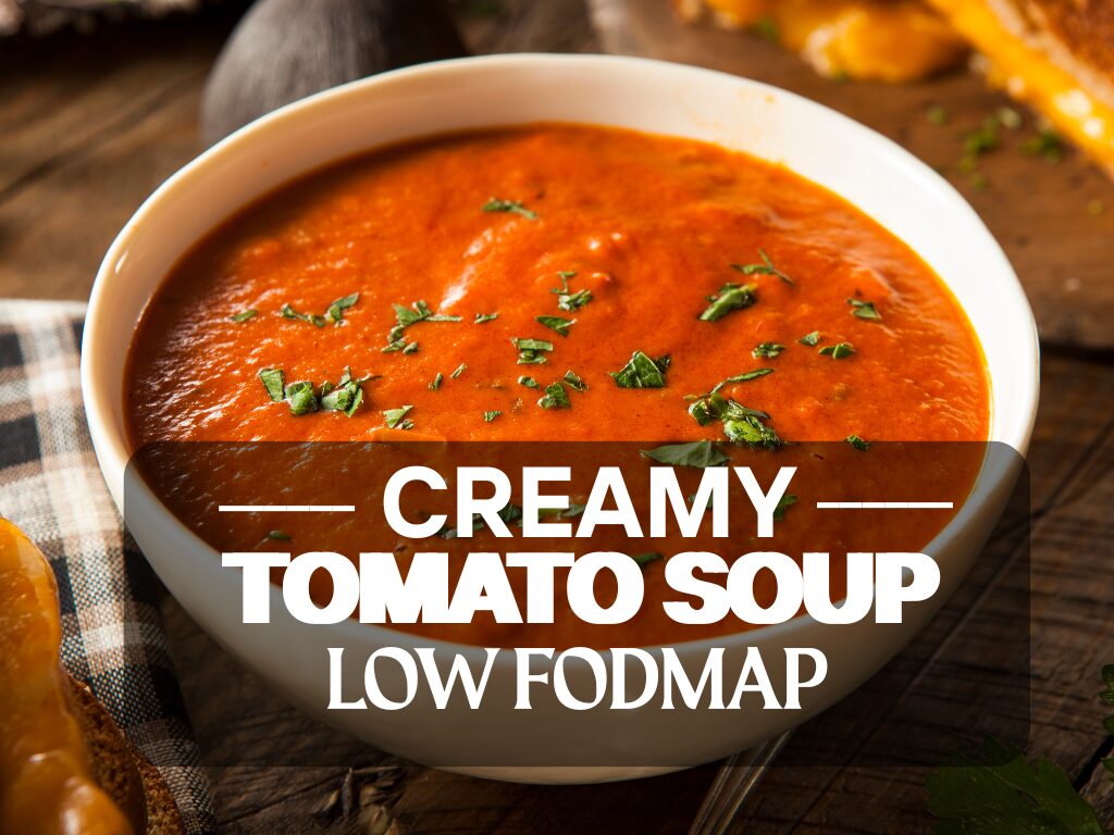 Bowl of creamy low FODMAP tomato soup garnished with herbs, served with gluten-free bread.