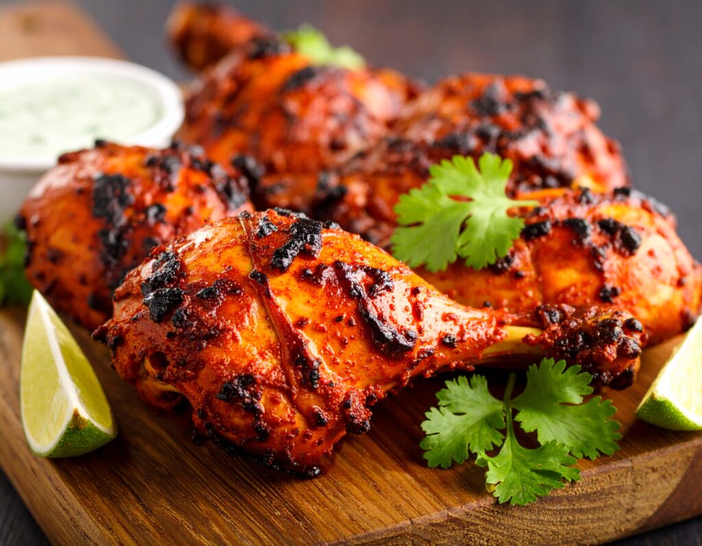 Close-up of grilled Tandoori Chicken with visible char marks and spice coating.